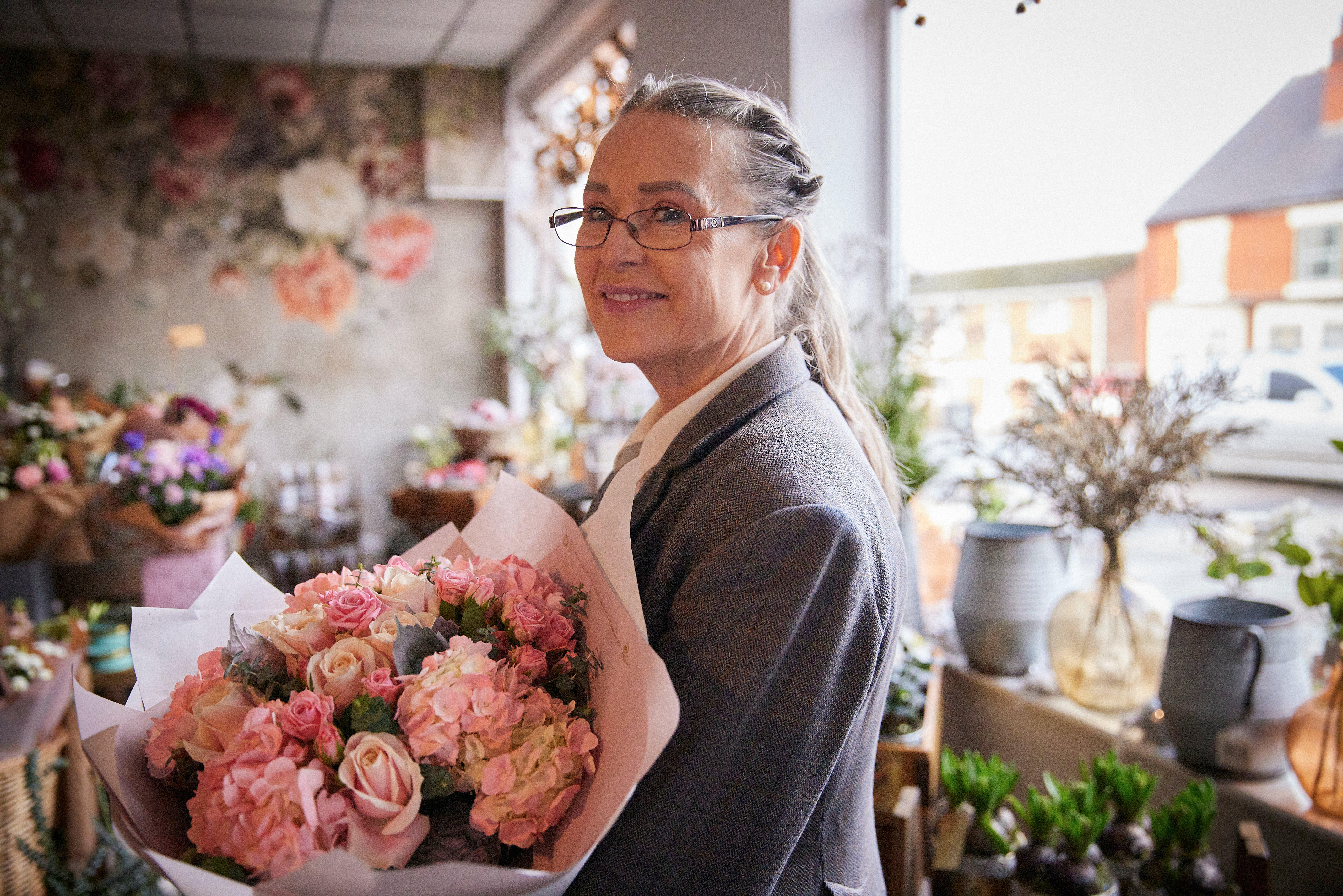 Interflora-florist-smiling-with-pastel-bouquet