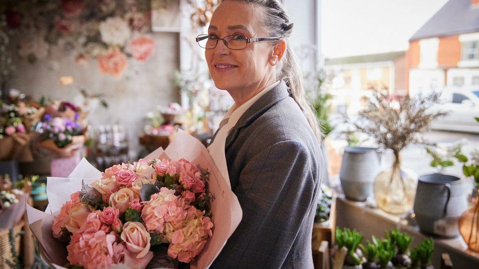 Interflora-florist-smiling-with-pastel-bouquet