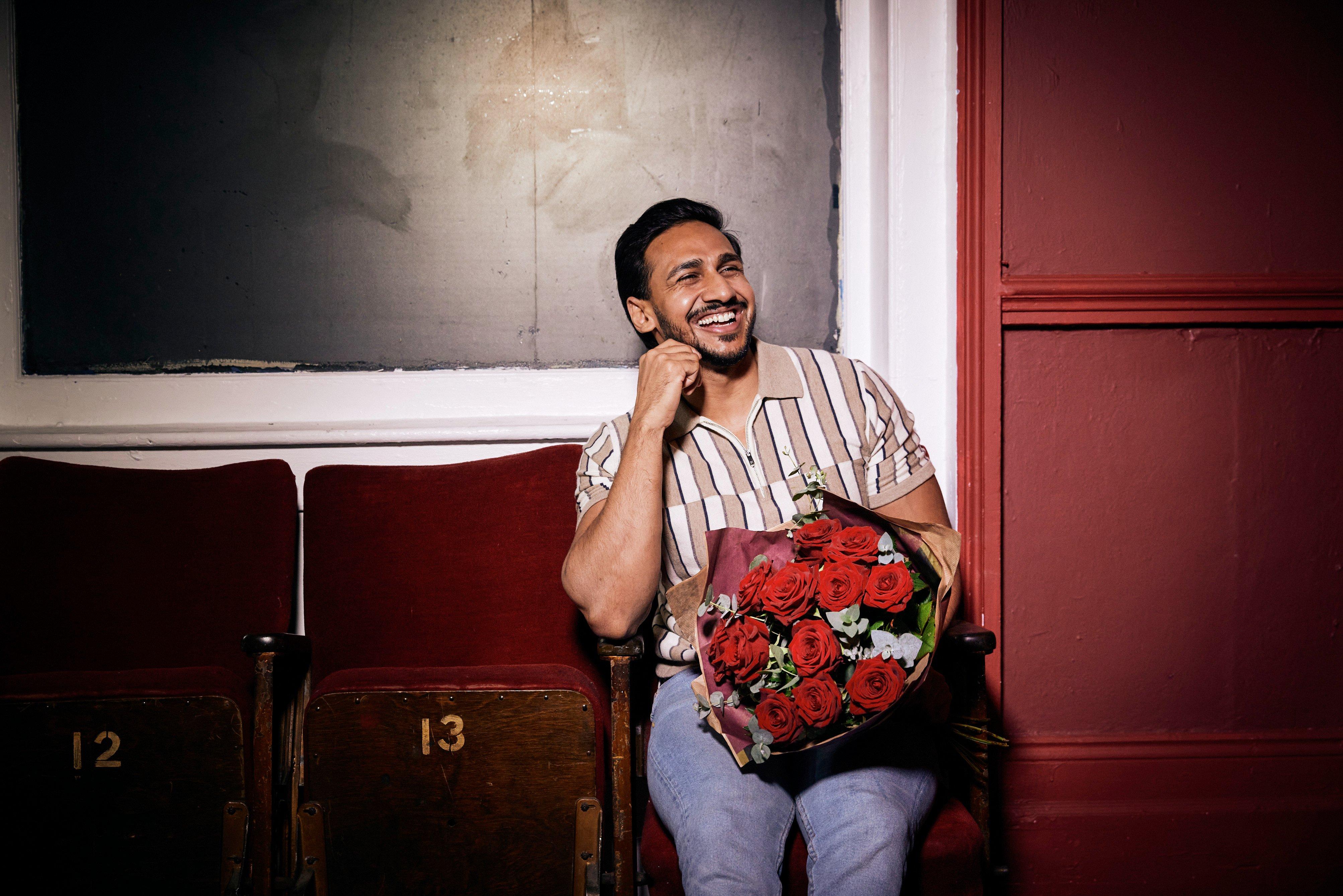 Man with red roses smiling