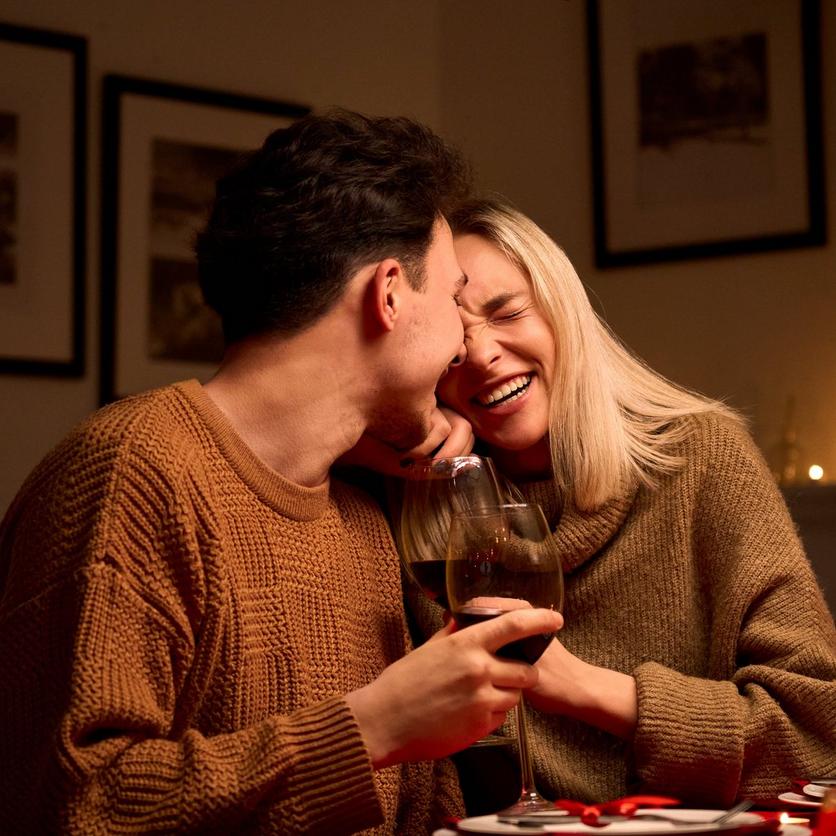 Man_and_woman_laughing_and_holding_glasses_of_wine