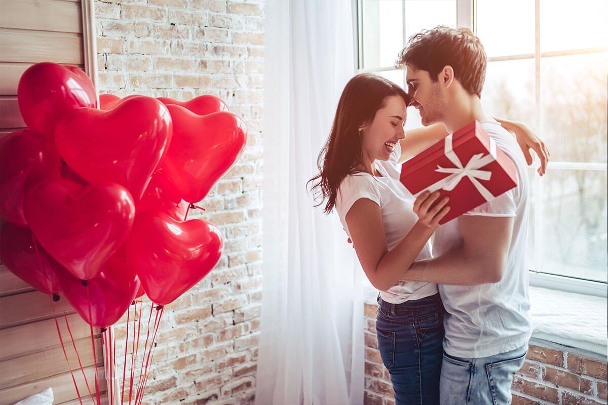couple-cuddling-next-to-heart-shaped-balloons