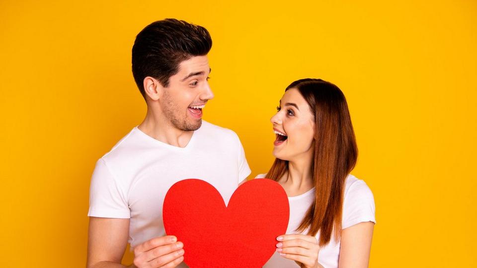 couple-smiling-at-eachother-with-heart-cutout