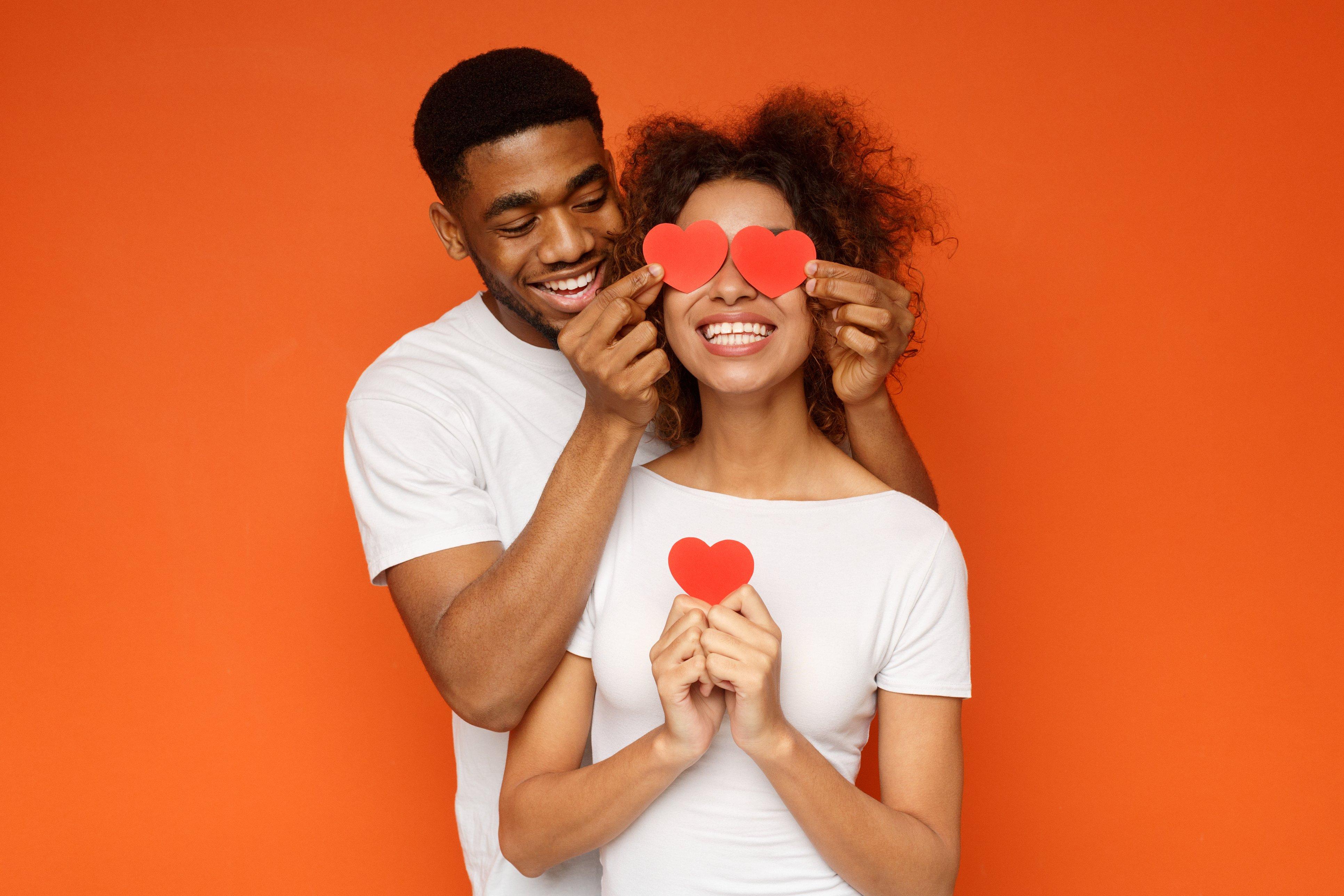 couple-together-smiling-orange-background