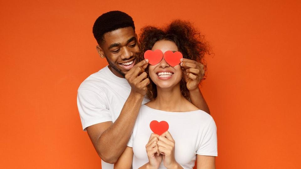 couple-together-smiling-orange-background