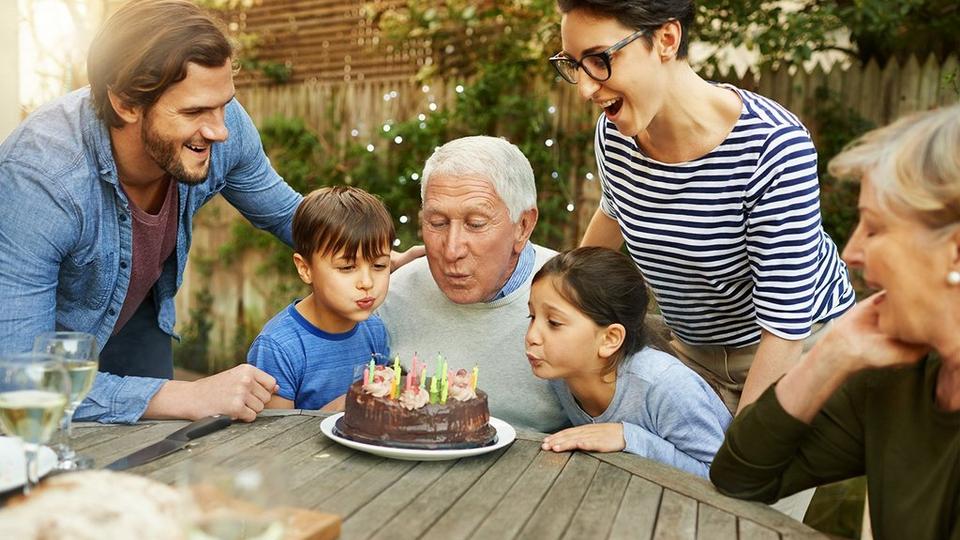 family-blowing-out-candles-on-cake