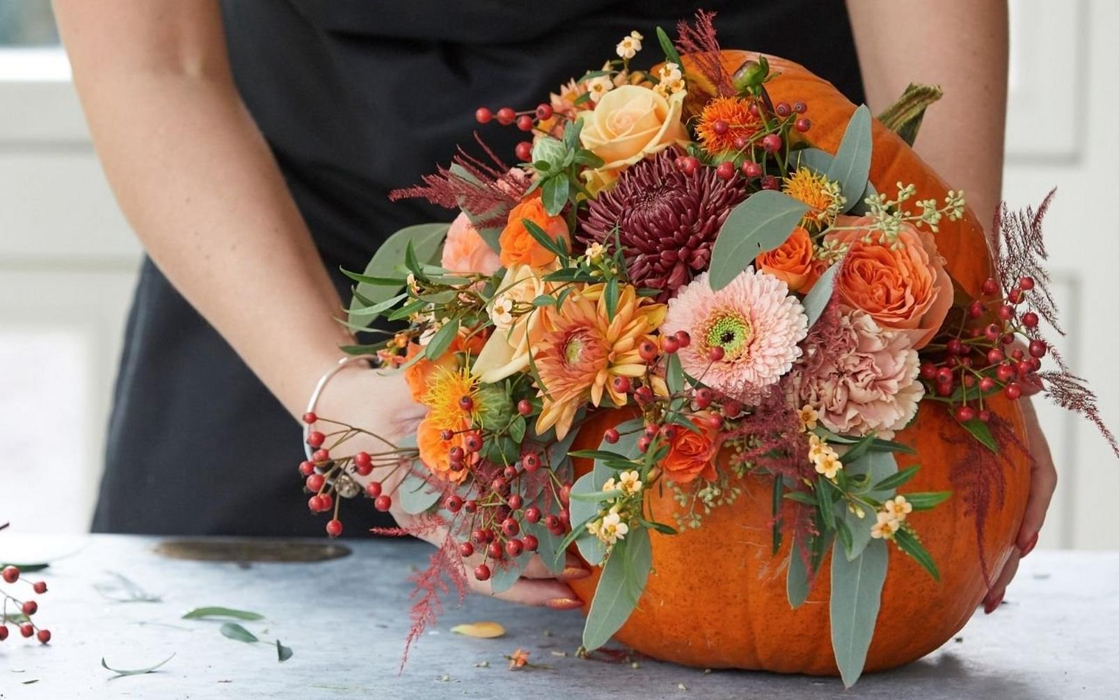 florist-adding-finishing-touch-to-pumpkin-arrangement