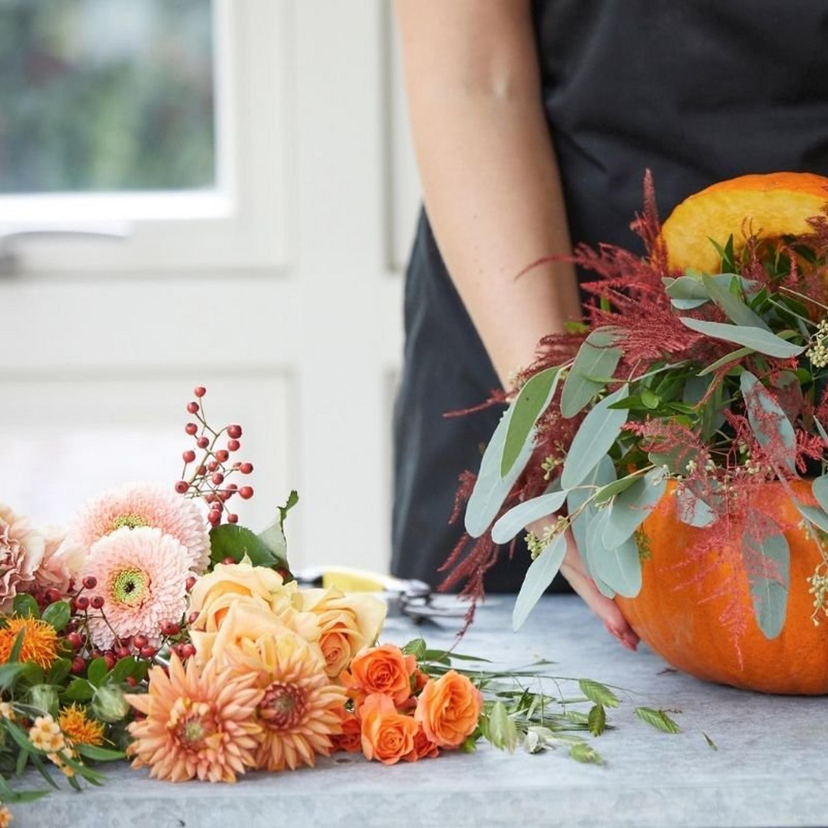 florist-adding-flowers-to-pumpkin-arrangement