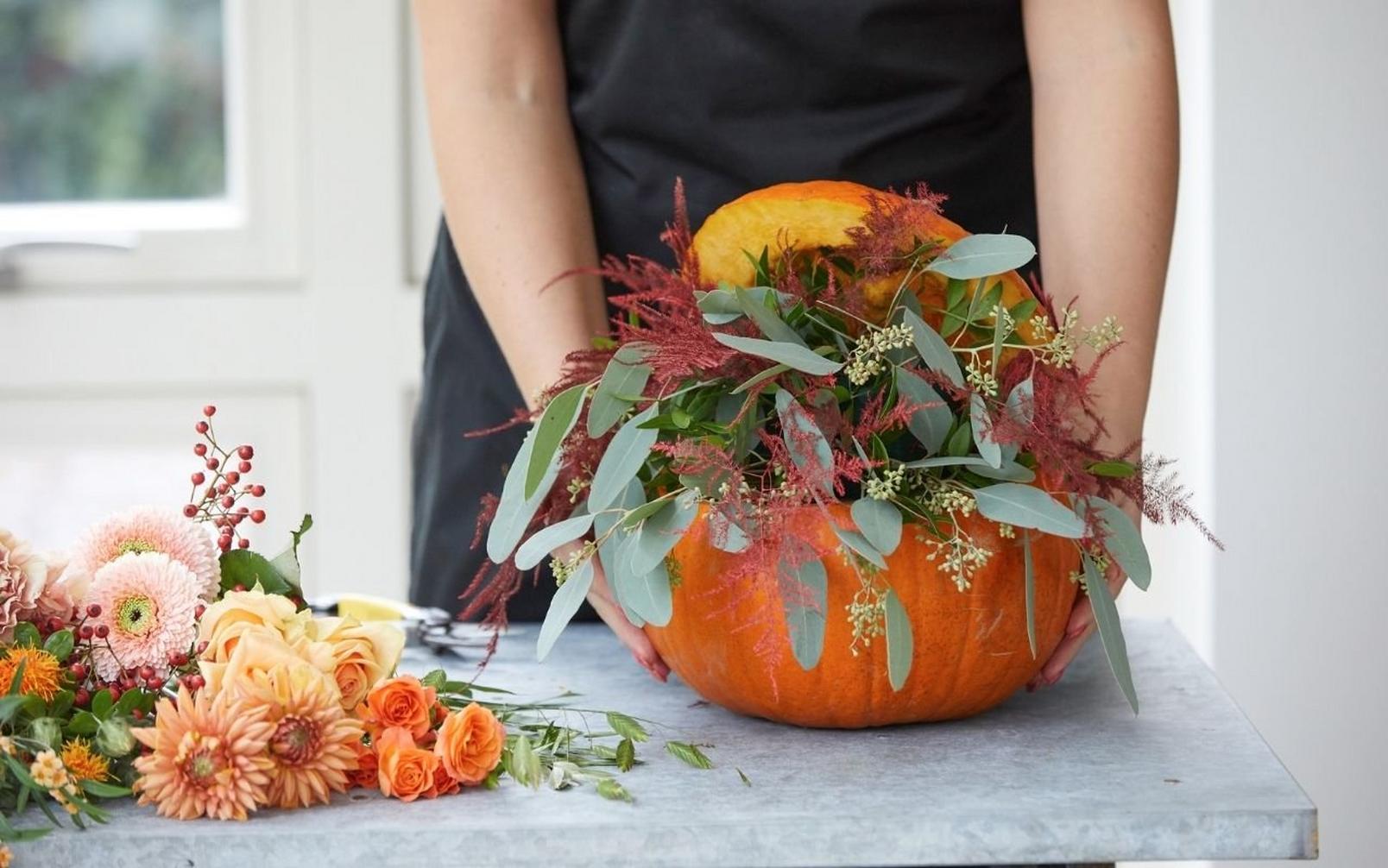 florist-adding-flowers-to-pumpkin-arrangement