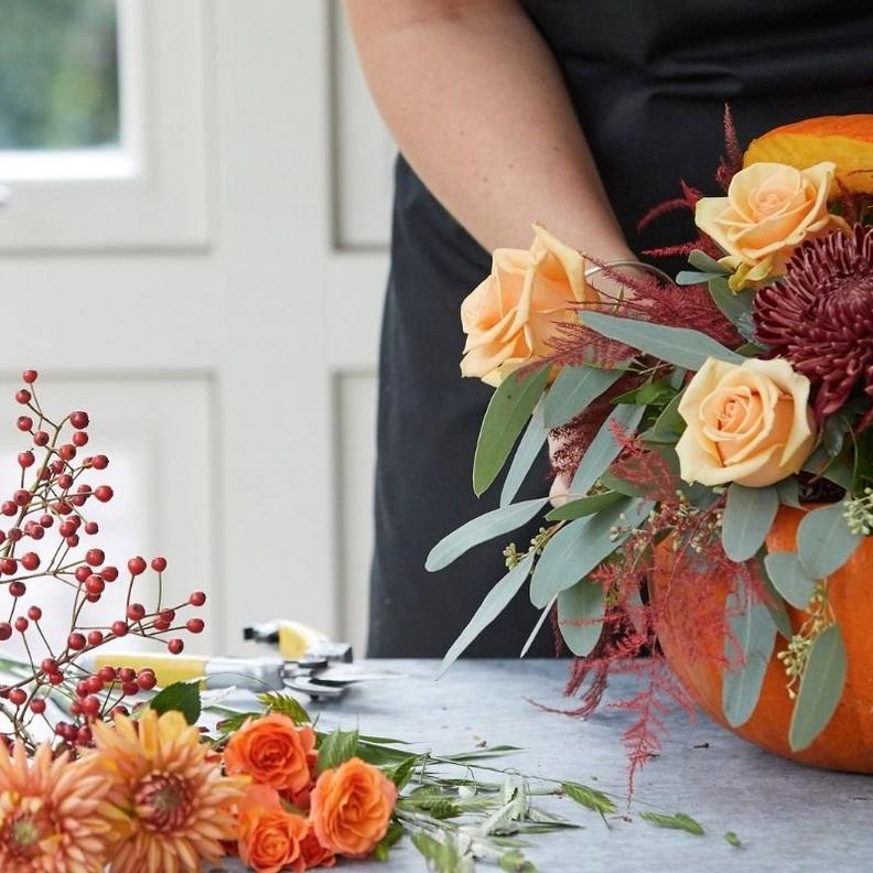 florist-arranging-roses-in-pumpkin-arrangement