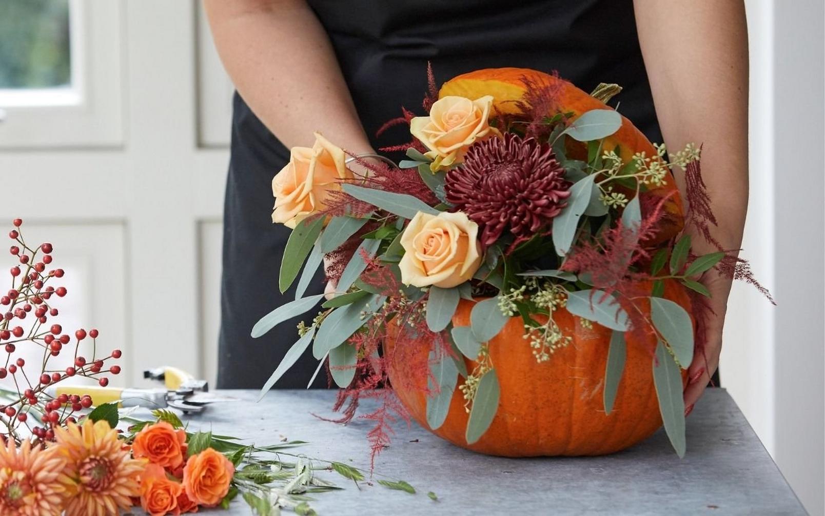 florist-arranging-roses-in-pumpkin-arrangement