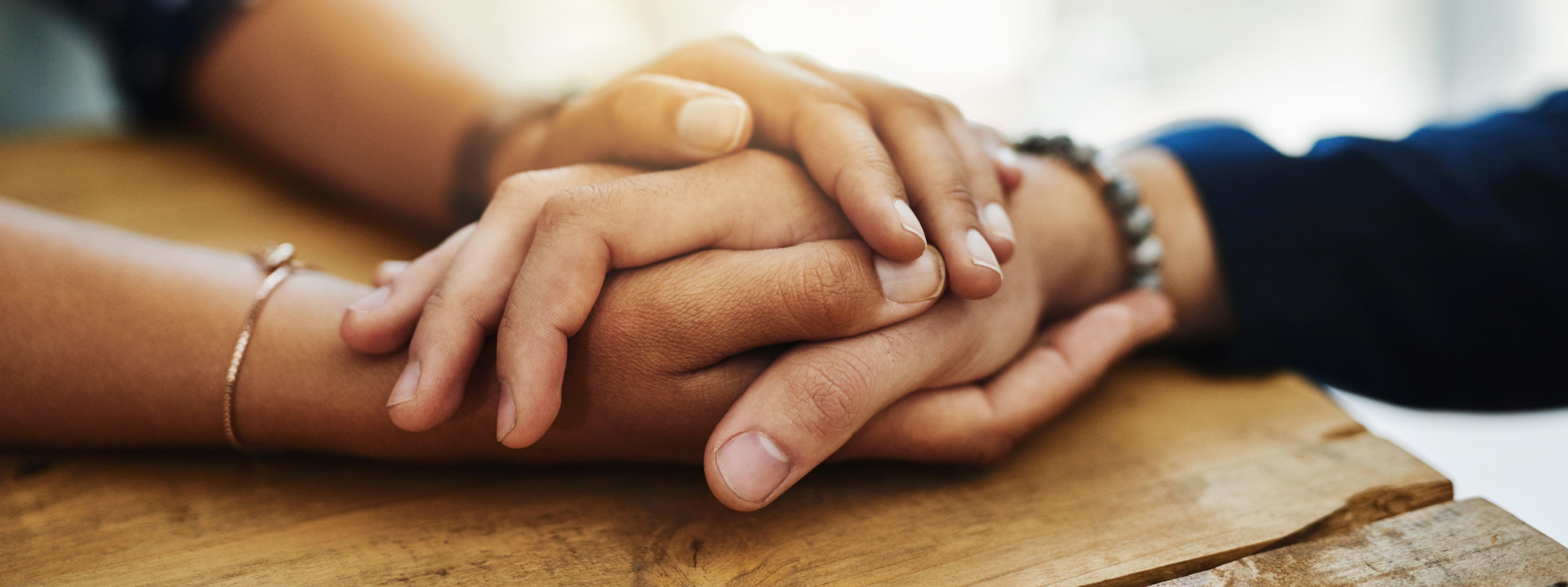 people-embracing-each-others-hands-sympathy