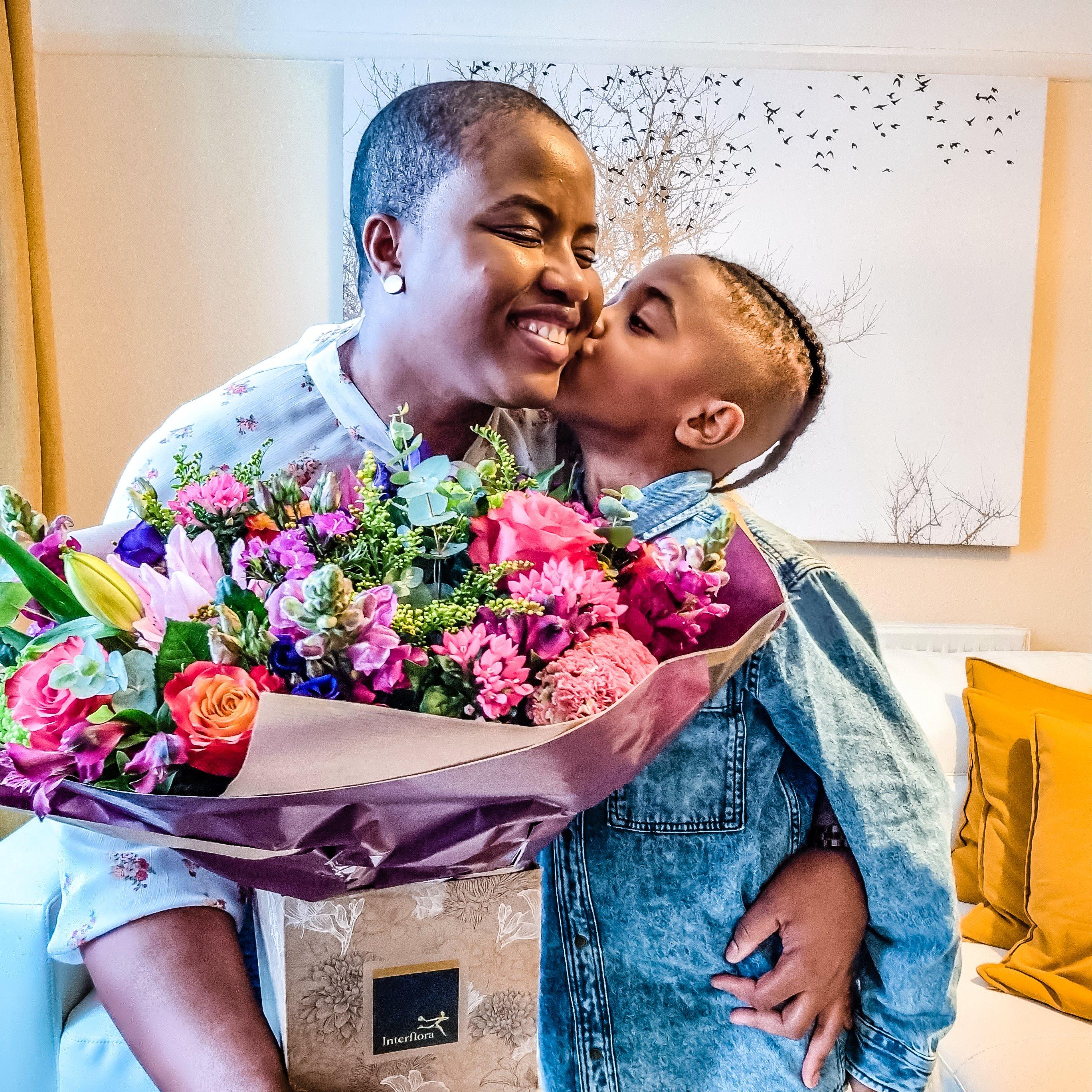 recipient-receiving-bouquet-and-kiss-from-child