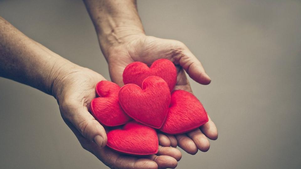 stock-image-hands-holding-red-hearts