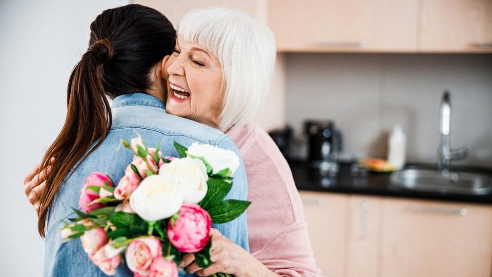 women-hugging-received-flowers